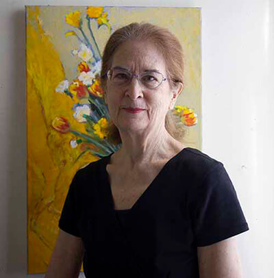 Annie standing in front of one of her art pieces